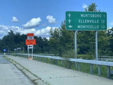 A green distance sign: Wurtsboro 1, Ellenville 12, Monticello 13.