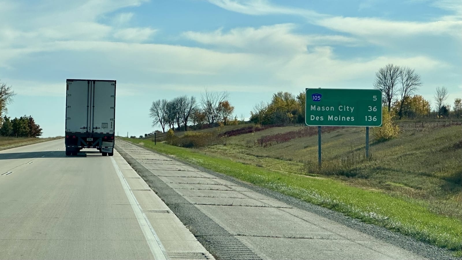A green distance sign: Iowa 105 5, Mason City 36, Des Moines 136.