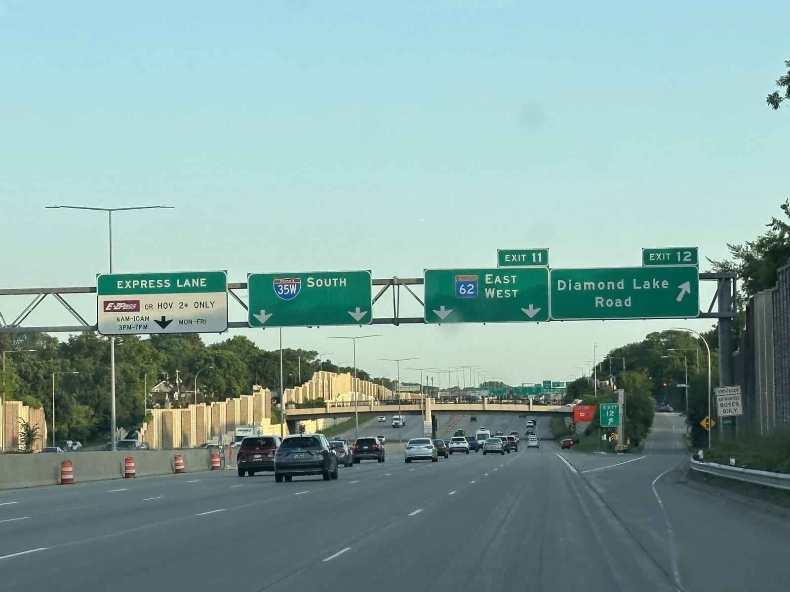 Overhead signs on I-35W: Express Lane (E-ZPass or HOV 2+ only, 6AM-10AM and 3PM-7PM), 35W South, Exit 11 for 62 East and West, and Exit 12 Diamond Lake Road.
